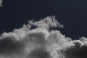 Cloudscape scenery, overcast weather above dark blue sky. Storm clouds floating in a rainy dull day with natural light. White and grey scenic environment background. Nature view. photo