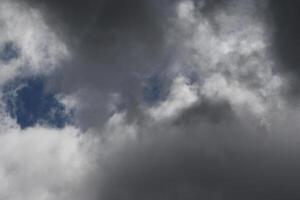 Cloudscape scenery, overcast weather above dark blue sky. Storm clouds floating in a rainy dull day with natural light. White and grey scenic environment background. Nature view. photo