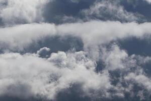 Cloudscape escenario, nublado clima encima oscuro azul cielo. tormenta nubes flotante en un lluvioso aburrido día con natural ligero. blanco y gris escénico ambiente antecedentes. naturaleza vista. foto