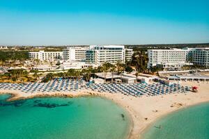 ayia napa, Chipre - 15 abril, 2023 - aéreo mosca terminado lujo hotel edificios con quinielas por playa con isla verdor panorama.blanco arena más famoso en Chipre - nisi playa foto