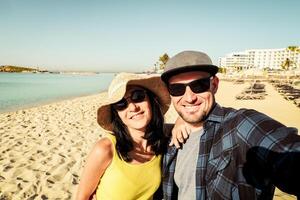 Happy traveling couple making selfie sea background . Sunny summer holidays. Romantic mood. Stylish sunglasses. Happy laughing emotional faces hipster multiracial. Cyprus holiday photo