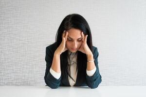 Caucasian young female director feel stressed at workplace, have problems working at empty desk. Frustrated ethnic woman worker anxious about company or business photo