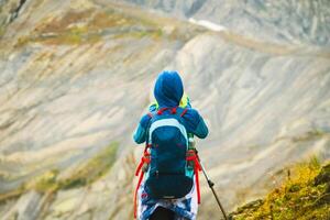 turista mujer caminante con mochila en montañas punto de vista tomar foto de paisaje en racha, georgiano región. udziro lago excursionismo sendero