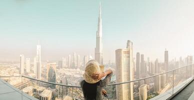 Dubai, UAE - 12th october, 2022 - Burj Khalifa View from sky view downtown, lady by infinity pool looking at the tallest building in the world. Visit Dubai sky view hotel on holiday photo