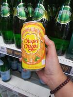 Bangkok, Thailand on July 22, 2023. A hand is holding a can of Chupa Chups Sparkling Orange Drink. photo