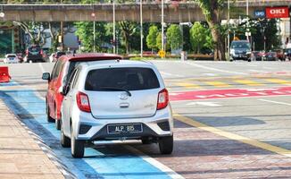 Kuala Lumpur, Malaysia on May 21, 2023. Several cars stop at a red light near the Dataran Merdeka square and Sultan Abdul Samad Building. photo