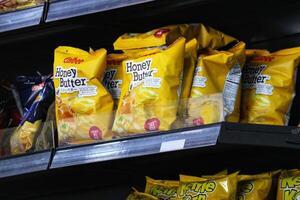 Manila, Philippines on September 29 2023. Calbee Honey Butter Potato Chips snack in the window of a shop at the airport photo