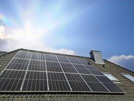 Solar panels producing clean energy on a roof of a residential house photo