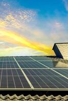 Solar panels producing clean energy on a roof of a residential house during sunset. photo