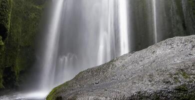 largo exposición de un cascada en un rocoso paisaje en Islandia foto