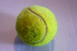 Colorful tennis ball in front of a white paper background photo