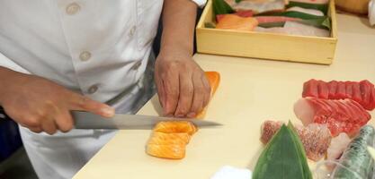 Hand was sliced fish to make sushi photo