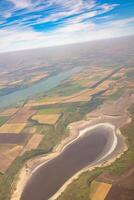 Land view through the airplane window. Fields, roads, rivers from a bird's eye view. Porthole. Look out the window of a flying plane. Top view of the ground photo