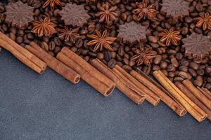 Food background. Coffee beans, cinnamon sticks, anise stars and chocolate candies. photo