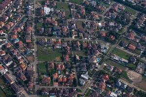 Residential area, rooftops, view from a drone. Cottages in the village. Land view through the airplane window. . Look out the window of a flying plane. Top view of the ground photo