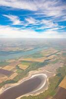 tierra ver mediante el avión ventana. campos, carreteras, ríos desde un aves ojo vista. porta. Mira fuera el ventana de un volador avión. parte superior ver de el suelo foto