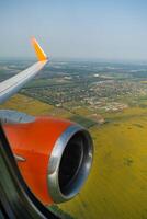 Land view through the airplane window. Fields, roads, rivers from a bird's eye view. Porthole. Look out the window of a flying plane. Top view of the ground photo