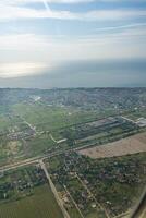 tierra ver mediante el avión ventana. campos, carreteras, ríos desde un aves ojo vista. porta. Mira fuera el ventana de un volador avión. parte superior ver de el suelo foto