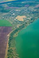 Land view through the airplane window. Fields, roads, rivers from a bird's eye view. Porthole. Look out the window of a flying plane. Top view of the ground photo