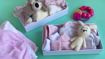 Baby and child clothes and knitted toys in carton box. video