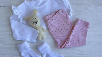 Set of baby bodysuits, pants, socks and knitted toy video