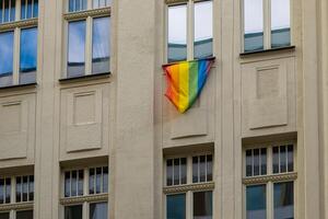 rainbow flag hanging from a window as a sign of tolerance photo