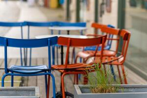 red and blue chairs in front of a street cafe in the city photo