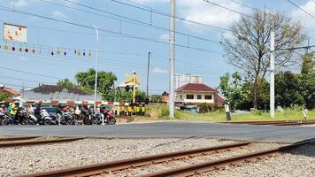 tráfego às uma estrada de ferro cruzando dentro surakarta, Indonésia video