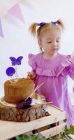 Cute little girl celebrate Happy Birthday and licks lollipops on a sweet cake video