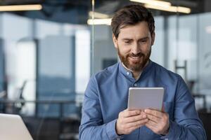 Smiling business professional browsing on a tablet inside a contemporary office space, symbolizing connectivity and technology. photo