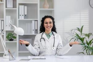 A professional Hispanic woman doctor is engaging in a call consultation in a well-lit office setting. photo