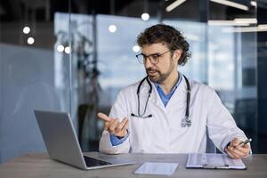 cuidado de la salud profesional en blanco laboratorio Saco comprometido en un telesalud llamar, Proporcionar remoto consulta utilizando digital dispositivos en un moderno clínica ajuste. foto