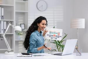 Smiling Hispanic woman at home office presenting a document during a call, showing productivity and multitasking. photo