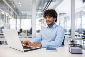 enfocado profesional trabajando en un ordenador portátil en un brillante, contemporáneo oficina espacio, encarnando productividad y corporativo estilo de vida. foto