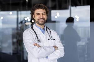 un acogedor Hispano masculino médico con un confidente sonrisa, en pie en un moderno hospital o clínica ambiente, exudando profesionalismo y calor. foto