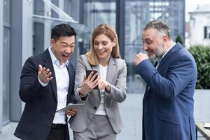 Tres colegas empleados reloj gracioso s o Mira a fotos, imágenes recuerdos mirando a teléfono inteligente pantalla utilizando móvil teléfono. grupo de negocio personas oficina trabajadores teniendo divertido en rompe foto