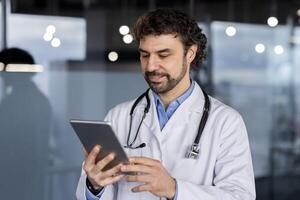 un profesional médico en un blanco Saco utilizando un digital tableta en un médico instalación, reflejando cuidado de la salud innovación y pericia. foto