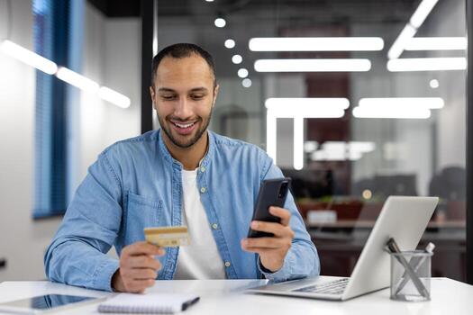 A man is smiling while using his cell phone to pay for something with a credit card. Concept of convenience and ease in making transactions using technology photo