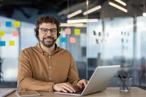 Focused individual participating in a business call using a laptop in a modern office setting. photo