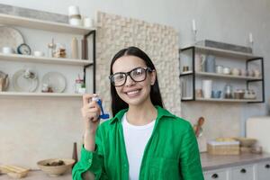 retrato de un joven hermosa mujer en lentes y un verde camisa foto