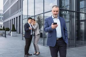 dos colegas son chismoso a antecedentes detrás el jefe. compañero de trabajo acerca de intimidación problema a trabajo sitio en oficina en el descanso fuera de masculino compañeros de trabajo empleados hombre y mujer susurro detrás atrás. foto