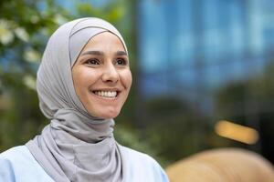 Elegant and modern young woman wearing a hijab against an urban backdrop, exuding confidence and style. photo