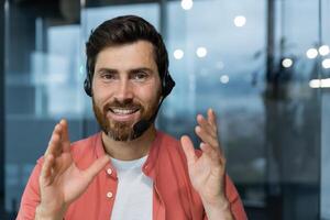 Close-up portrait of mature tech support worker, looking at camera and smiling, man talking on call ,customer helpline customer service online business man working inside modern office building. photo