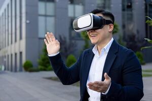 Enthusiastic businessman in a suit interacts with virtual reality, smiling and waving against an urban backdrop. photo