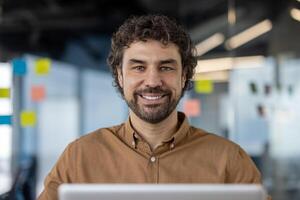 enfocado Hispano hombre utilizando un computadora en un contemporáneo espacio de trabajo, encarnando profesionalismo y determinación. foto