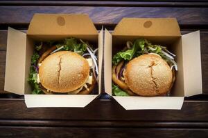 Freshly prepared burgers packed in boxes perfectly sealed for delivery and utmost taste preservation photo