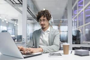 enfocado adulto masculino oficina trabajador mostrando profesionalismo mientras utilizando ordenador portátil. emocionalmente invertido y experimentado en negocio tareas. foto