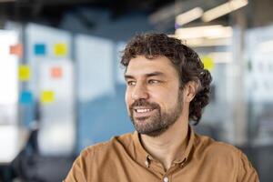 Joyful successful businessman close-up pensive and dreamy looking out window, smiling, mature experienced man at workplace inside office. photo