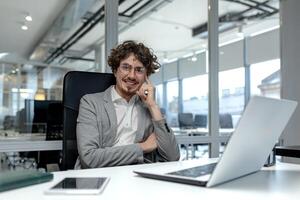 Adult male office worker displays professionalism and experience at his desk, radiating contentment and motivation in the corporate environment. photo