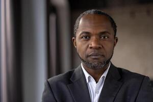 Close-up of a contemplative African American businessman in a suit, exuding professionalism and determination. photo